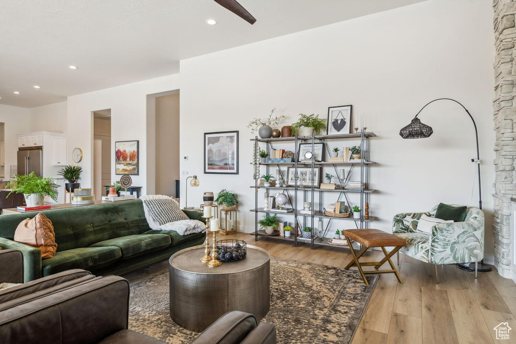 Living area with light wood-style flooring, ceiling fan, and recessed lighting