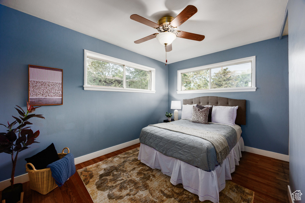Bedroom featuring multiple windows, wood finished floors, and a ceiling fan