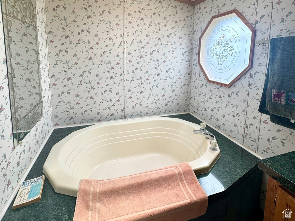 Full bath with crown molding, wallpapered walls, a skylight, a bath, and a textured ceiling