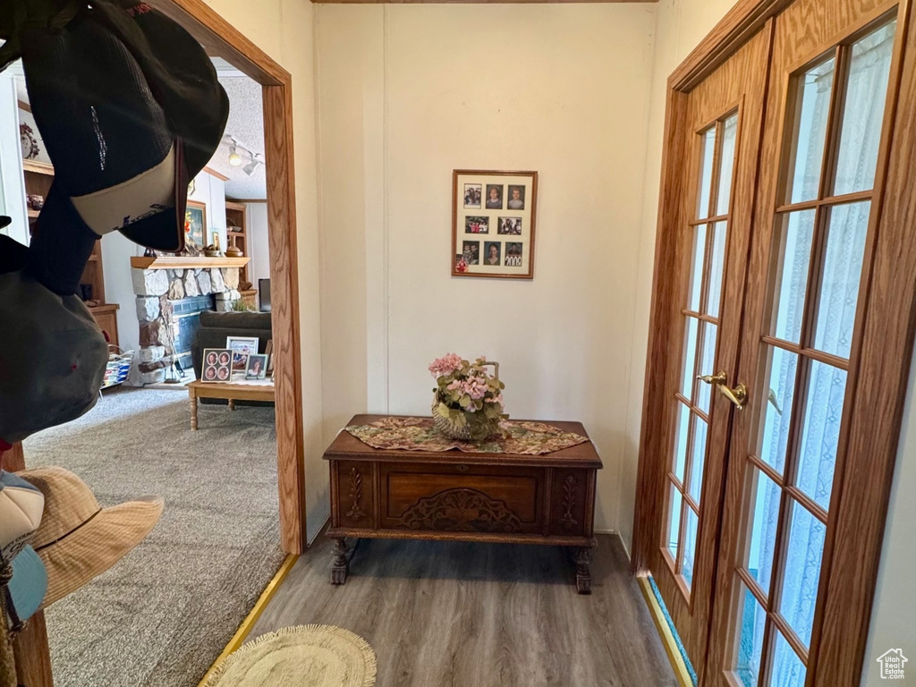 Entryway with ornamental molding, wood finished floors, a textured ceiling, healthy amount of natural light, and a fireplace