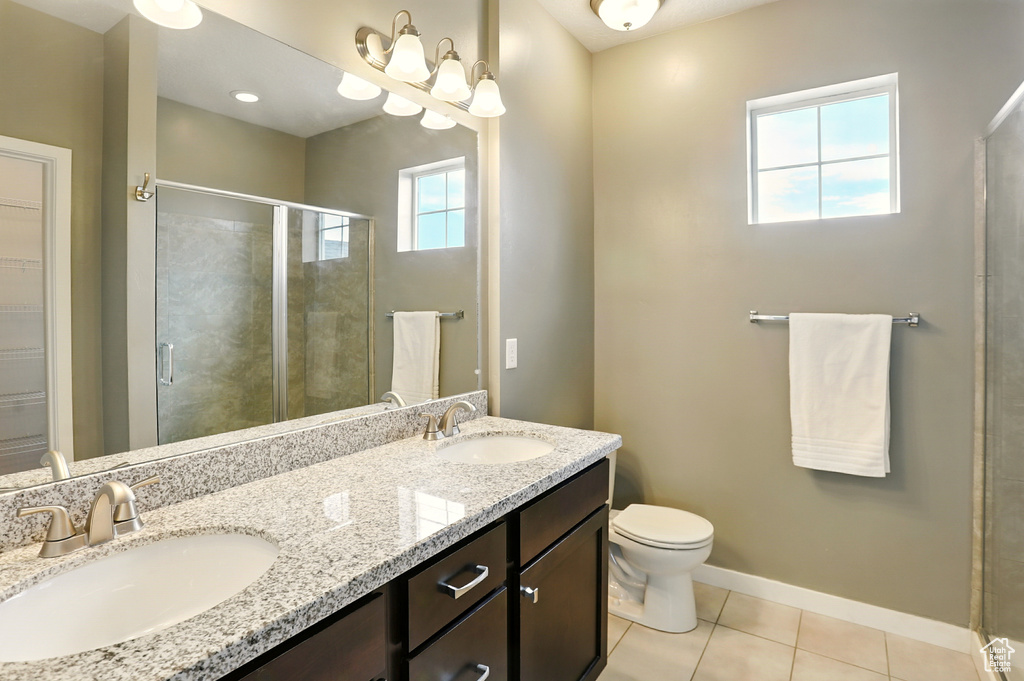 Bathroom with tile patterned floors, a stall shower, and double vanity