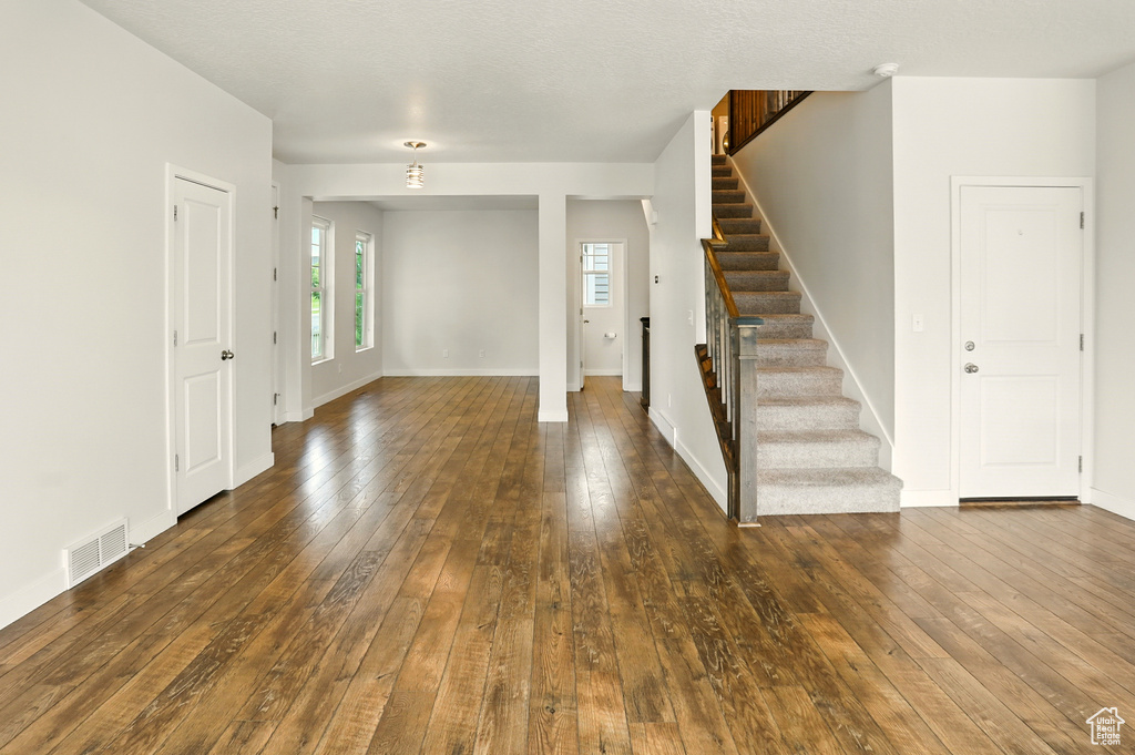 Entrance foyer featuring dark wood-type flooring and stairs