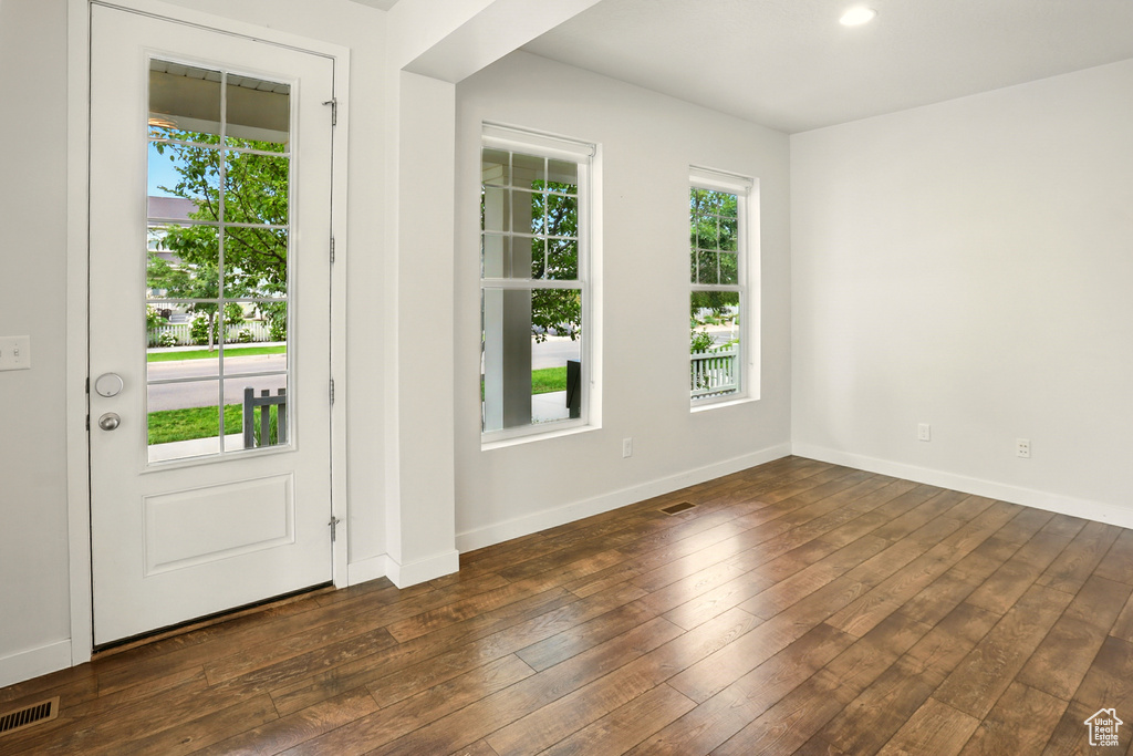 Doorway featuring dark wood finished floors and baseboards