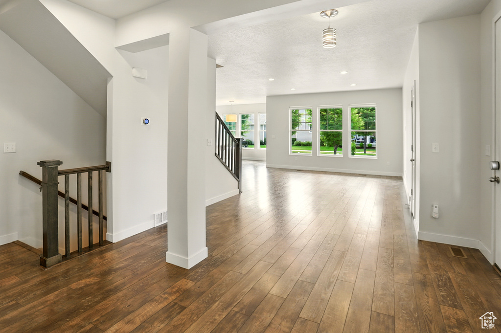 Hall featuring dark wood finished floors and stairway
