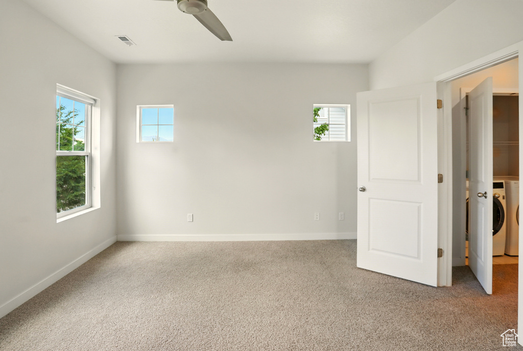 Unfurnished bedroom with carpet floors, washer / dryer, and a ceiling fan