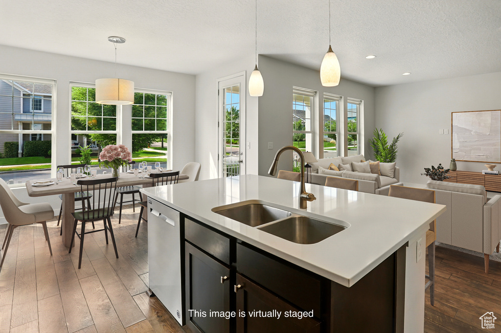 Kitchen with dishwasher, healthy amount of natural light, dark wood-type flooring, open floor plan, and recessed lighting