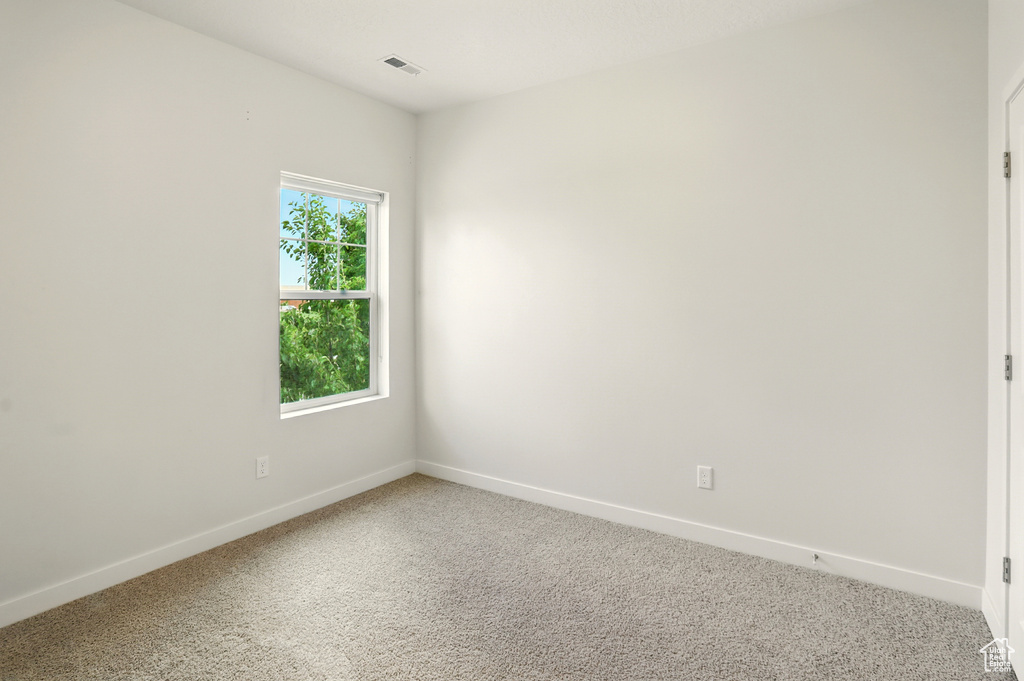 Empty room with baseboards and light carpet