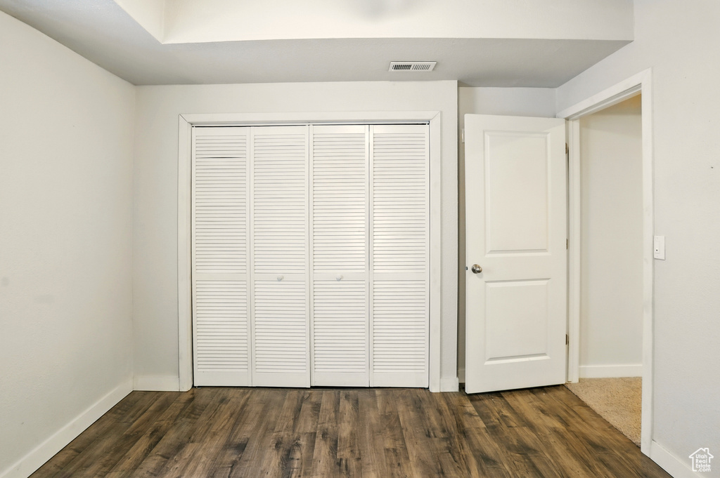 Unfurnished bedroom with dark wood finished floors and a closet