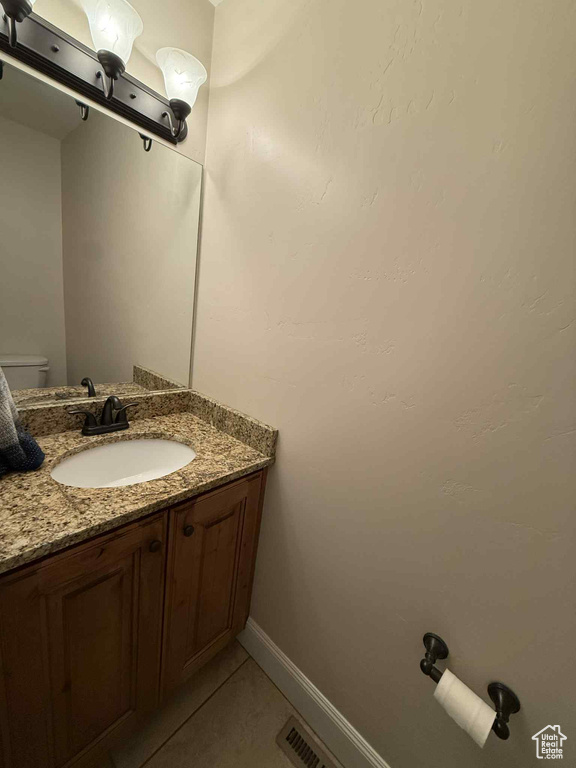 Half bath featuring vanity and tile patterned flooring