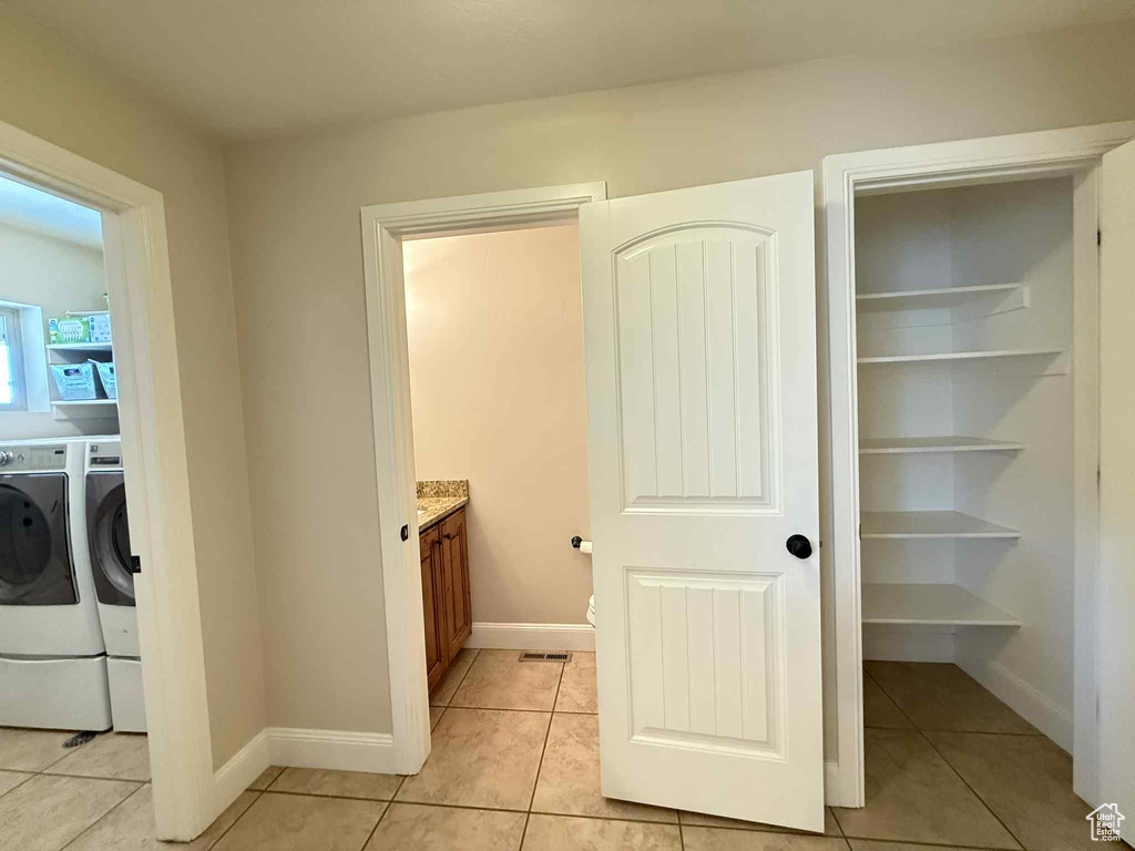 Laundry room with light tile patterned floors and separate washer and dryer