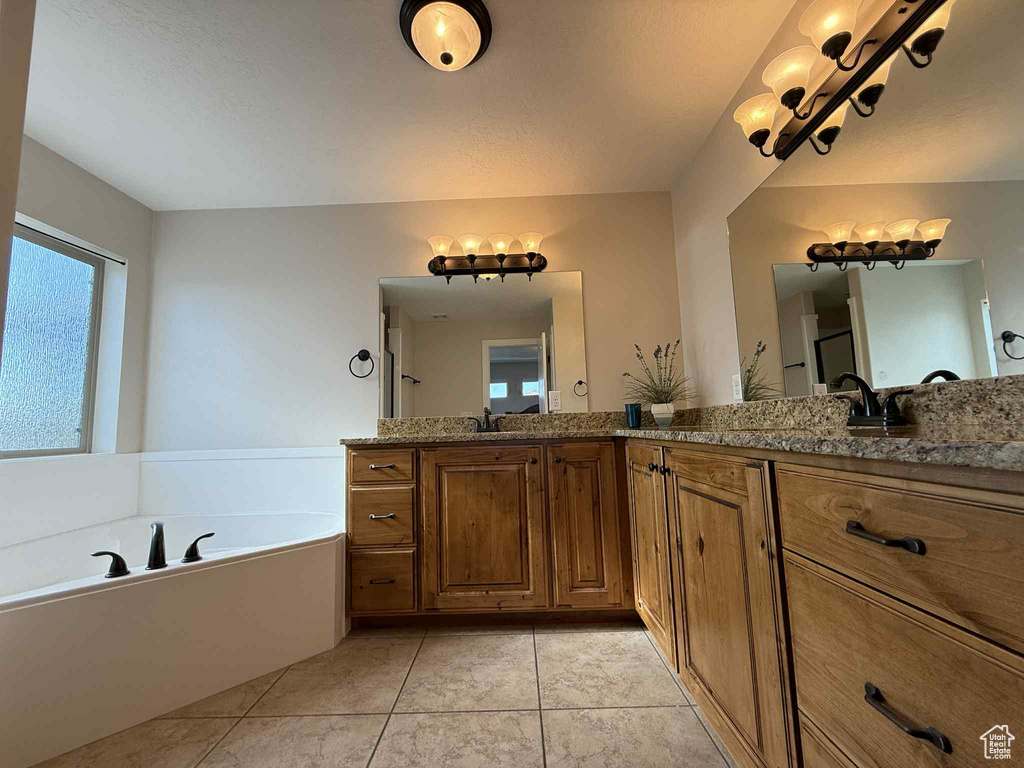 Bathroom featuring double vanity, a bath, and tile patterned flooring