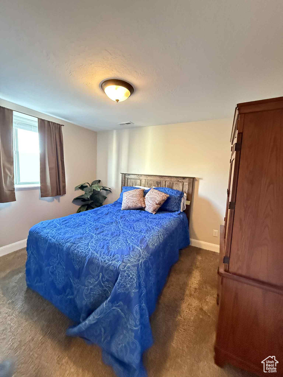 Bedroom featuring carpet floors and baseboards