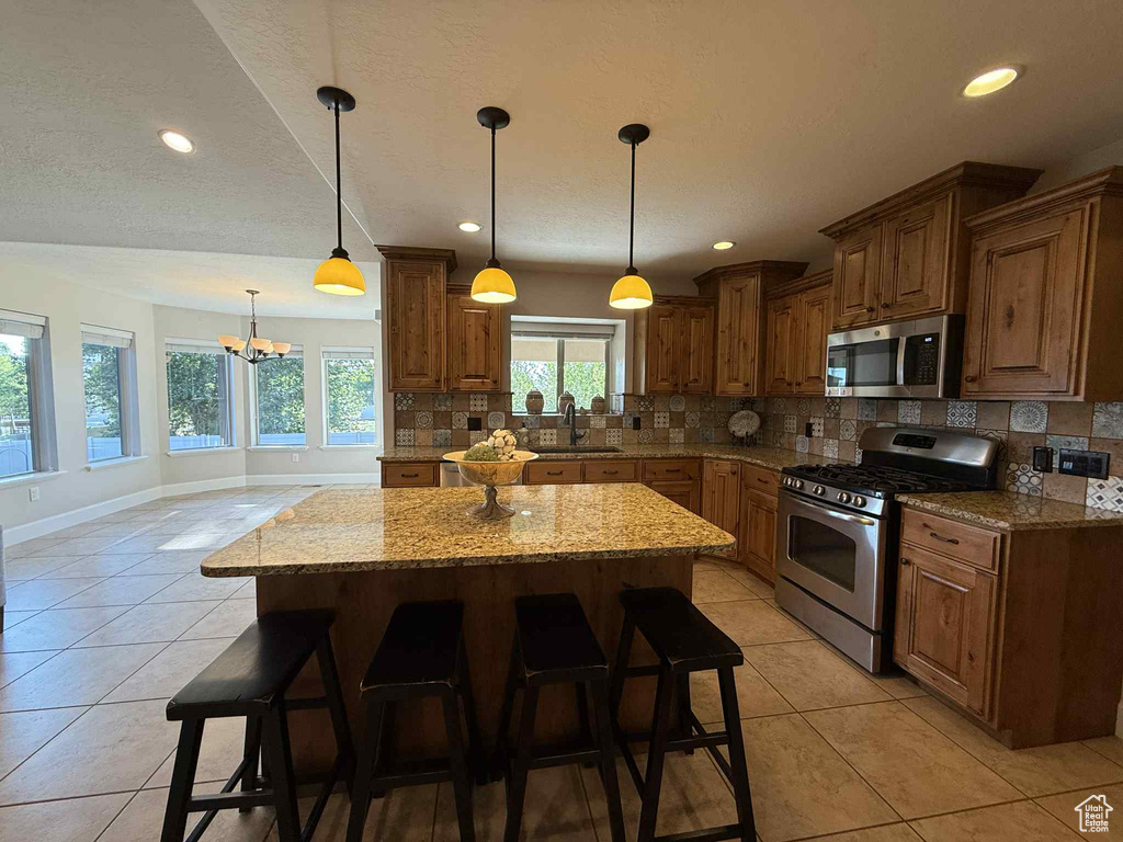 Kitchen featuring appliances with stainless steel finishes, decorative backsplash, light tile patterned flooring, and recessed lighting