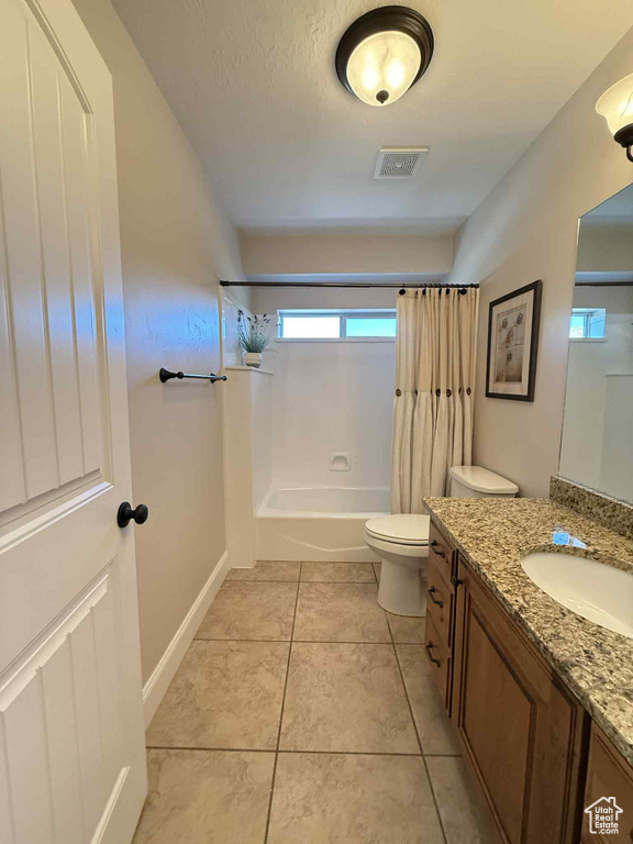 Bathroom with vanity, shower / tub combo, and tile patterned flooring