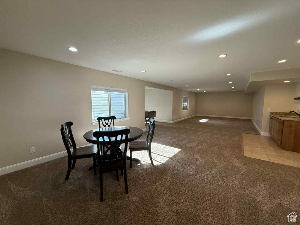 Dining room with light carpet and recessed lighting
