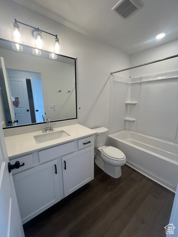 Bathroom featuring wood finished floors, vanity, and washtub / shower combination