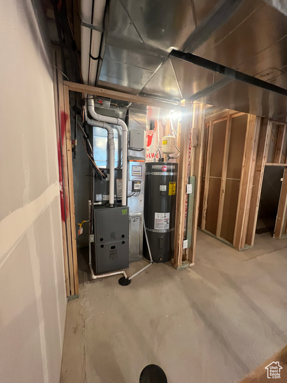 Utility room featuring secured water heater and heating unit