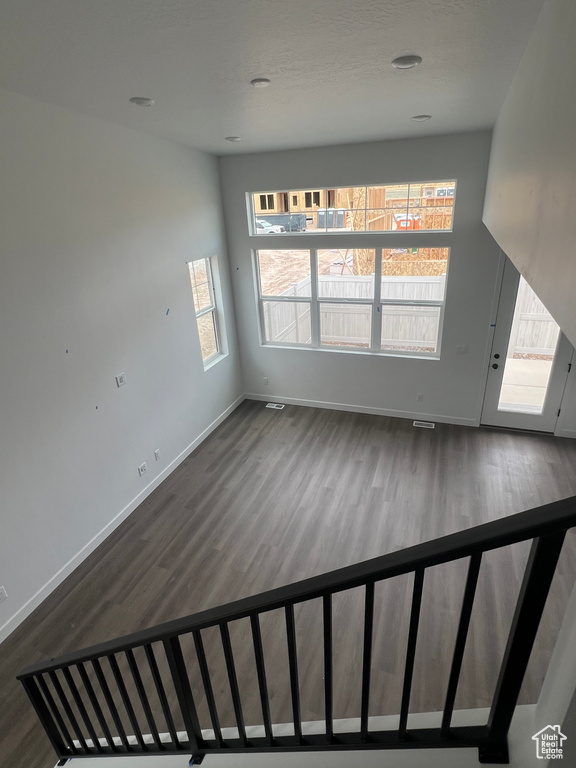 Unfurnished living room featuring wood finished floors and baseboards