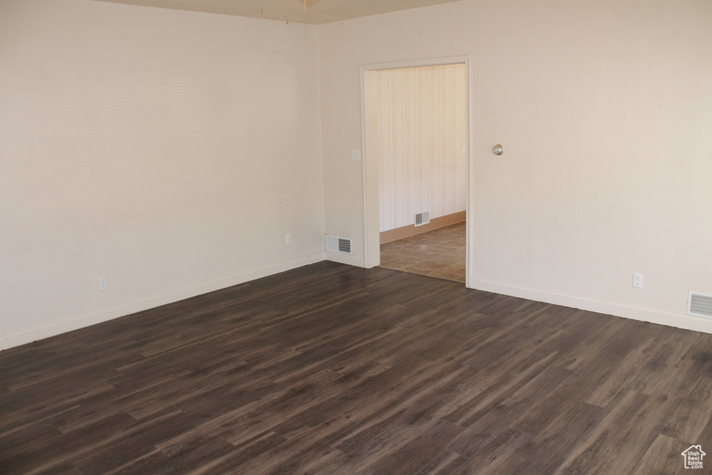 Unfurnished room with dark wood finished floors and baseboards