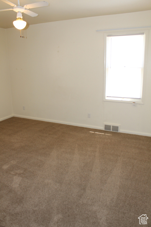 Unfurnished room featuring carpet and a ceiling fan