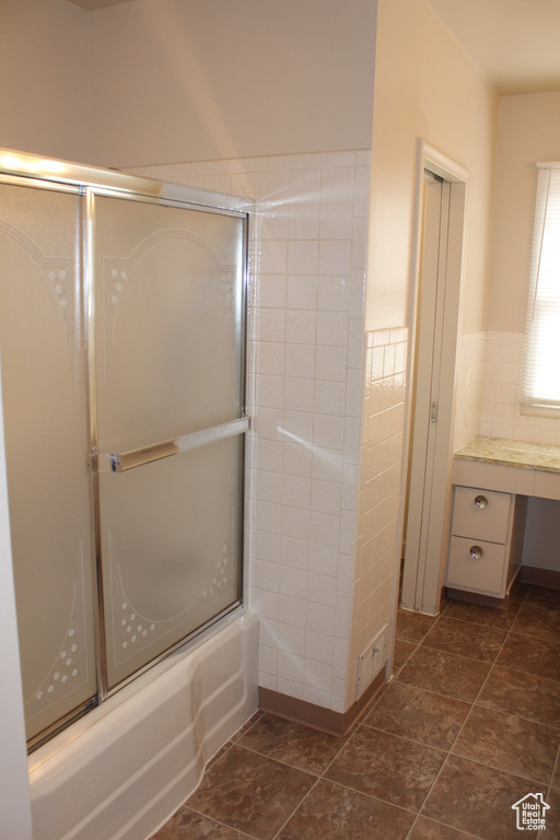 Bathroom featuring shower / bath combination with glass door and vanity