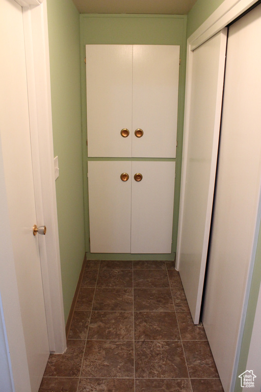 Hallway featuring dark stone finish floors