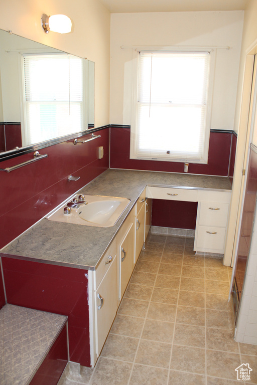 Bathroom featuring healthy amount of natural light, vanity, and tile patterned floors