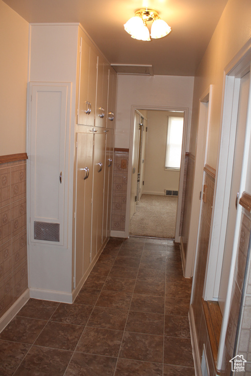 Hallway featuring a wainscoted wall and baseboards