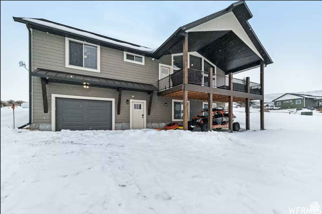 View of front of property featuring a standing seam roof and a garage