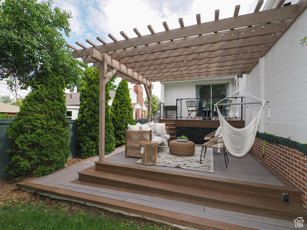 Wooden deck featuring a pergola and an outdoor hangout area
