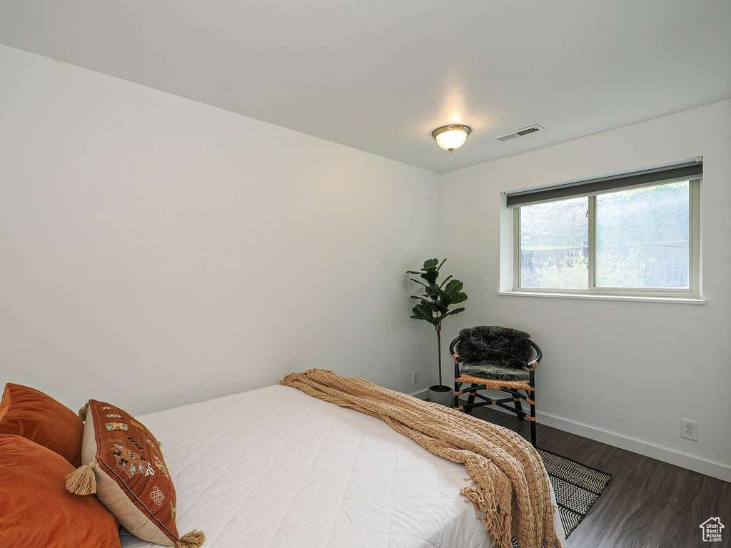 Bedroom with wood finished floors and baseboards