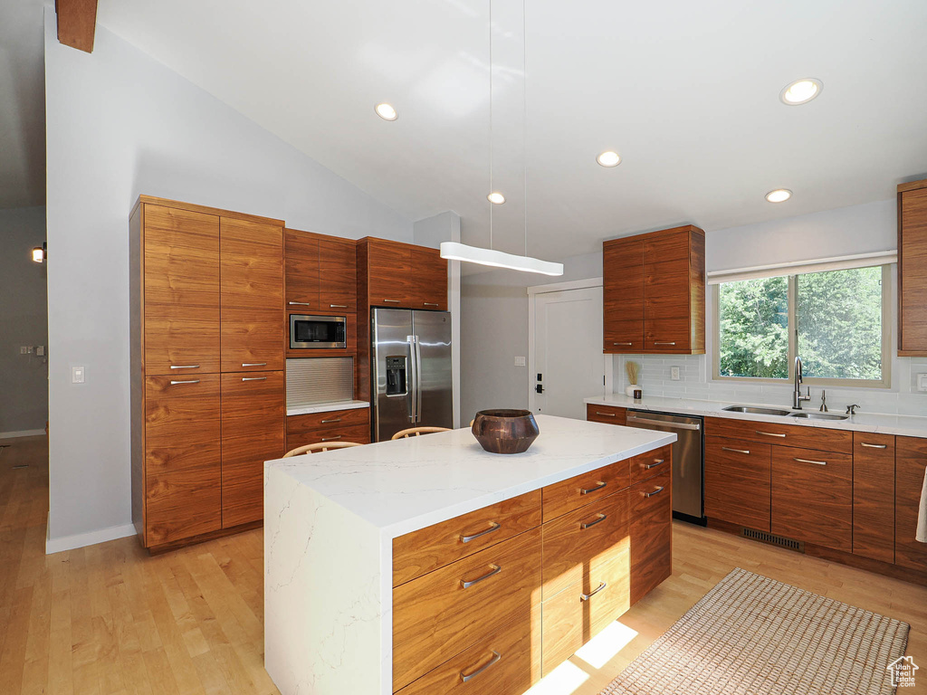 Kitchen with appliances with stainless steel finishes, modern cabinets, light wood-style floors, lofted ceiling, and recessed lighting