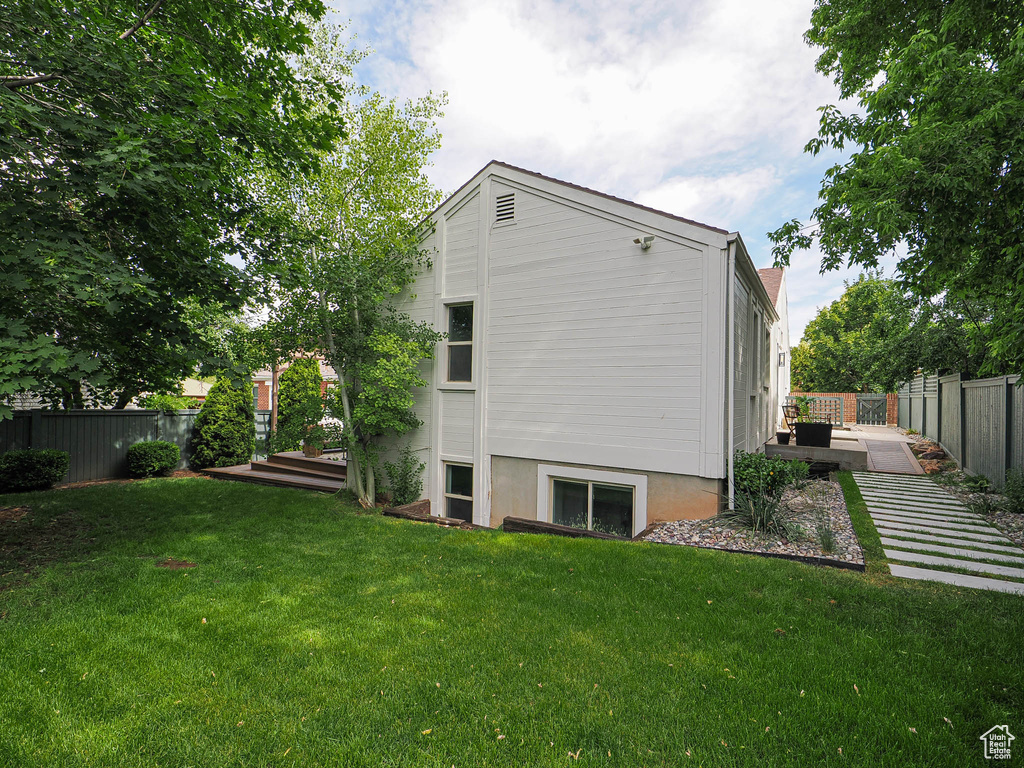 Back of house with a fenced backyard and a deck