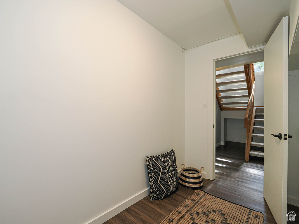 Hallway with dark wood-type flooring and stairs