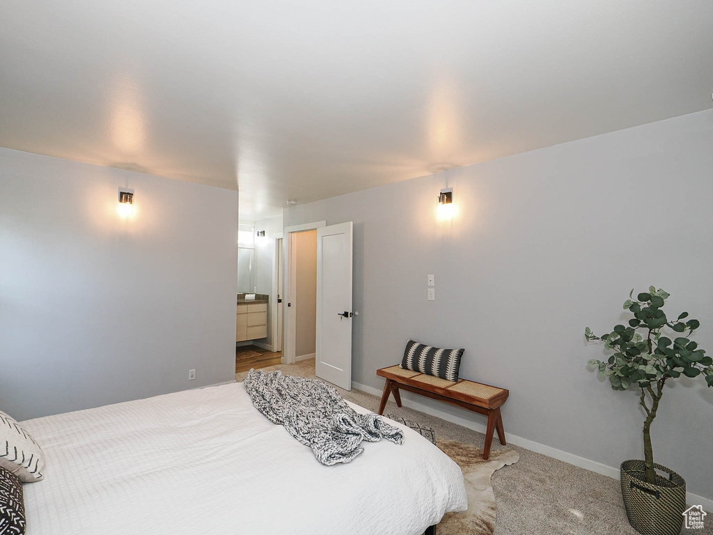 Bedroom with light carpet and ensuite bathroom