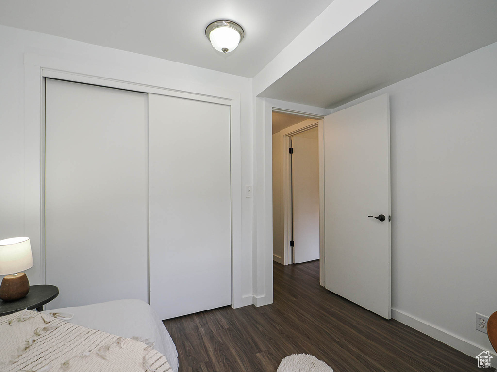 Bedroom featuring dark wood-type flooring and a closet