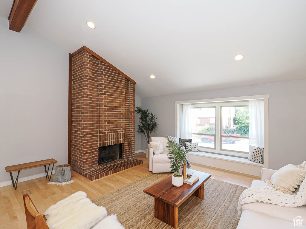 Living room featuring light wood-style floors, recessed lighting, and a fireplace