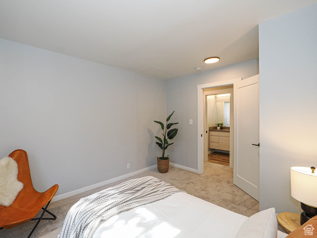 Bedroom featuring light carpet and baseboards