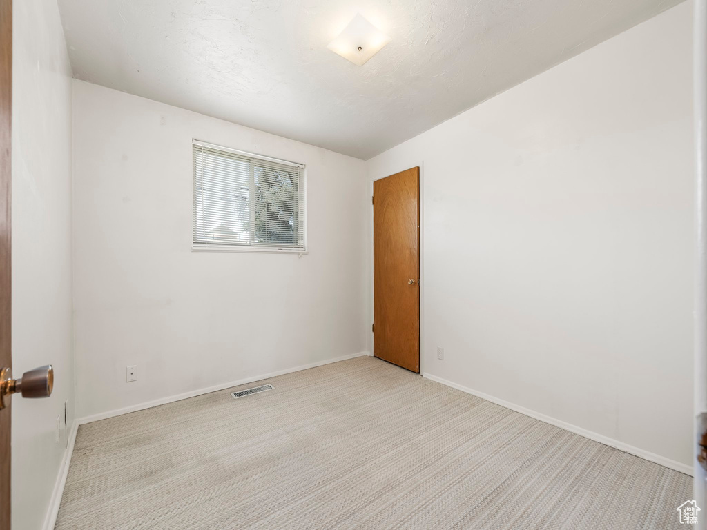 Empty room with carpet flooring and baseboards
