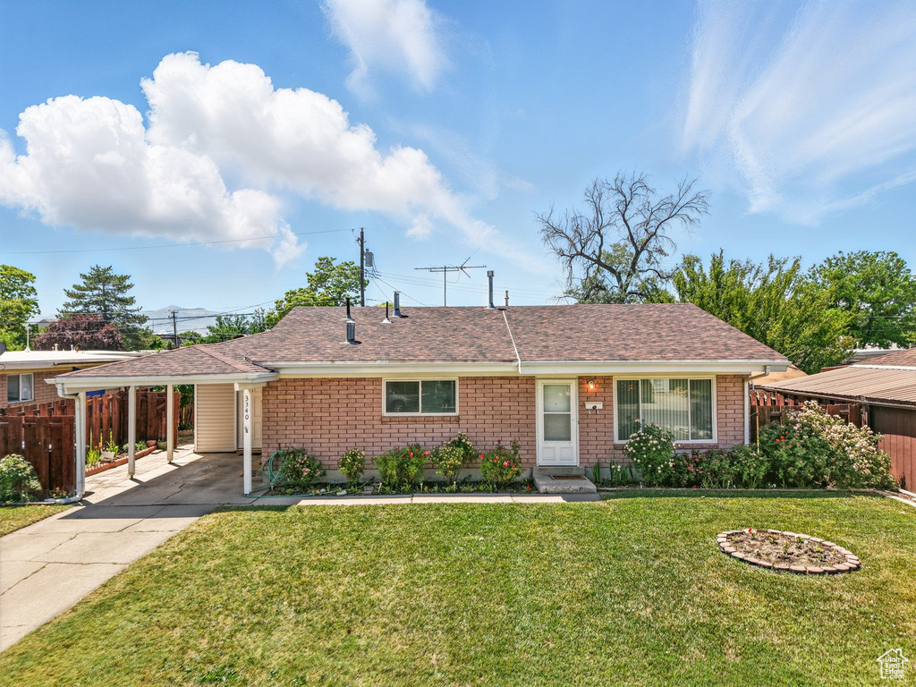 Ranch-style house featuring a carport, driveway, brick siding, and roof with shingles