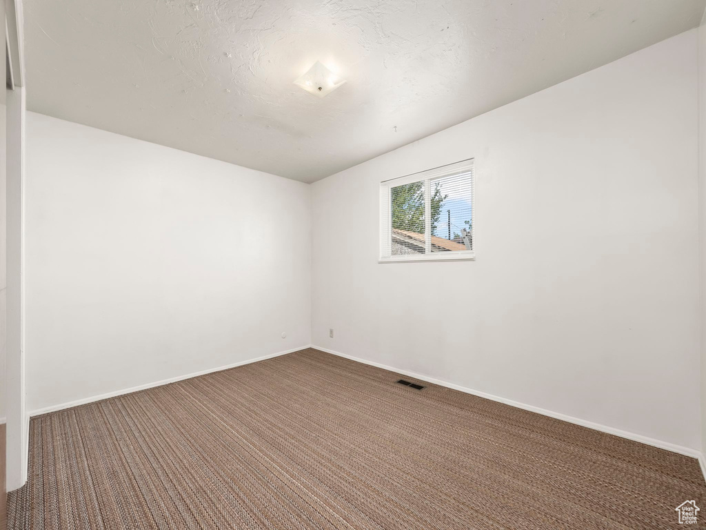 Spare room featuring carpet and baseboards