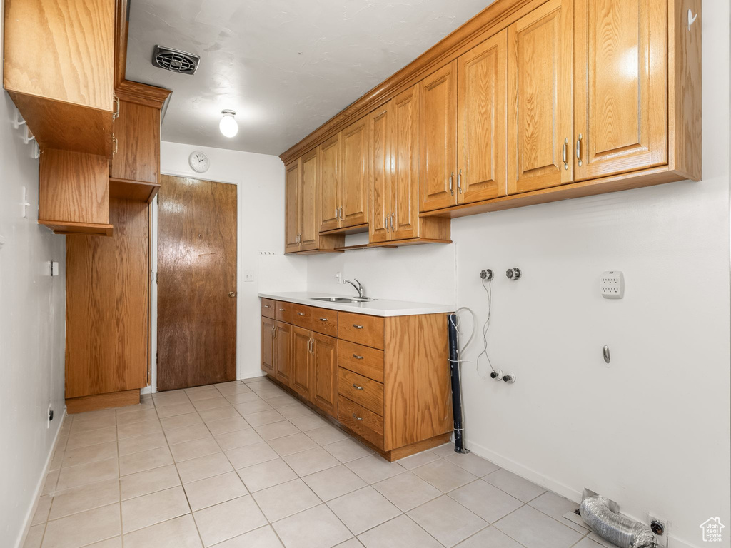 Laundry room featuring cabinet space, light tile patterned floors, and washer hookup