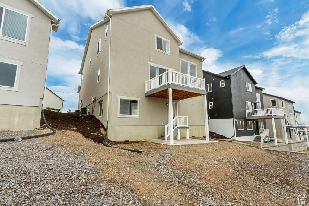 Back of property with a balcony and stucco siding