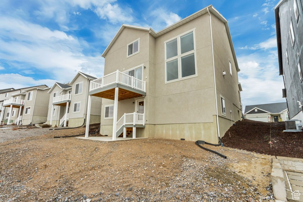Rear view of property featuring stucco siding and a balcony