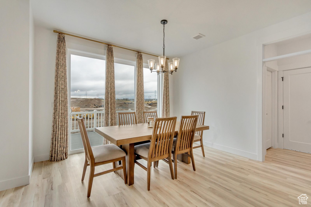 Dining space featuring light wood finished floors and a chandelier