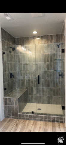 Full bath featuring a stall shower, recessed lighting, and wood finished floors