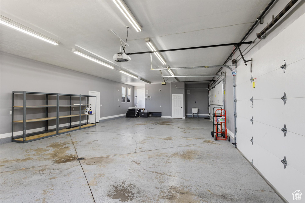 Garage with a garage door opener and baseboards