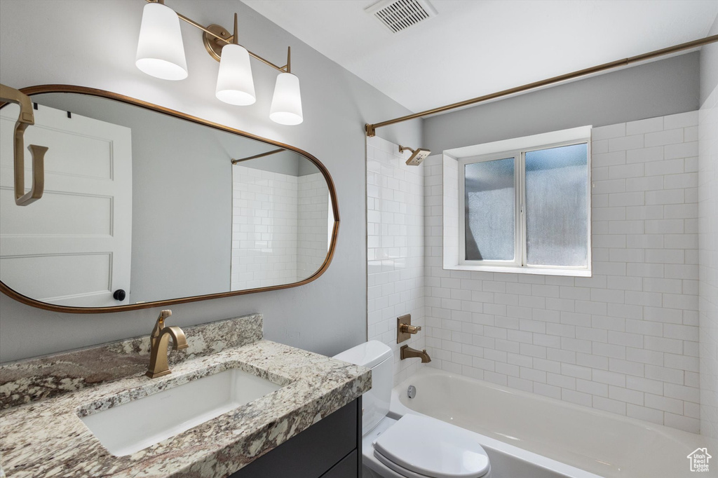 Bathroom featuring vanity and washtub / shower combination