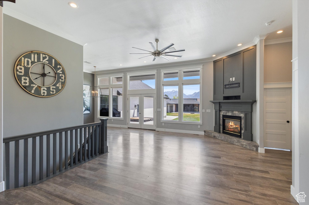 Unfurnished living room featuring a fireplace, wood finished floors, recessed lighting, crown molding, and ceiling fan