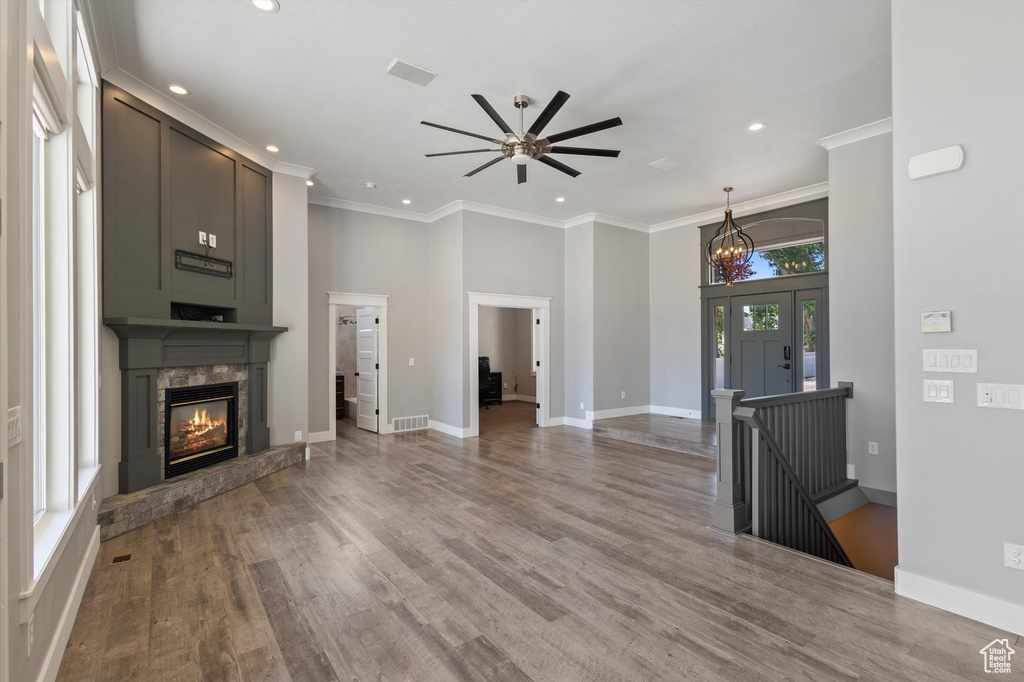 Unfurnished living room with recessed lighting, a fireplace, ceiling fan, crown molding, and wood finished floors